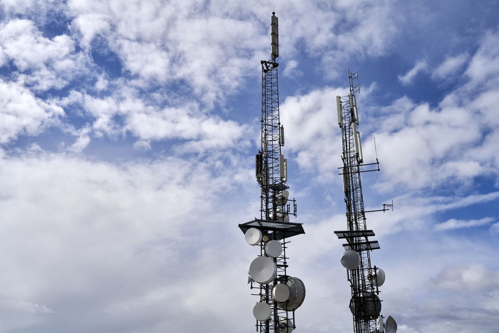 Telecom towers against a cloudy sky