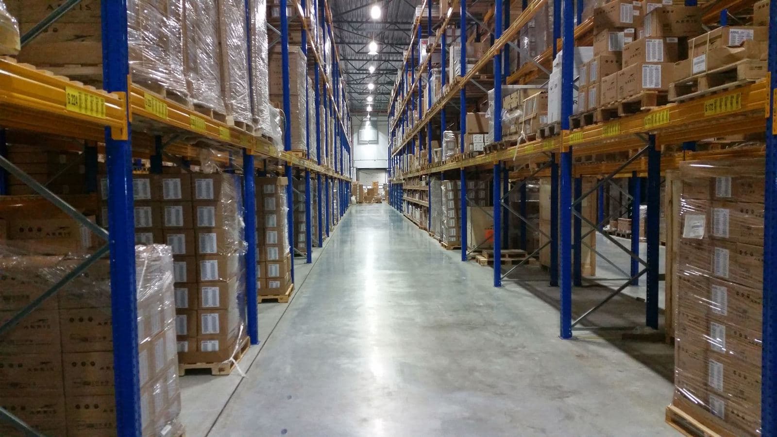 Warehouse aisle lined with tall pallet racks