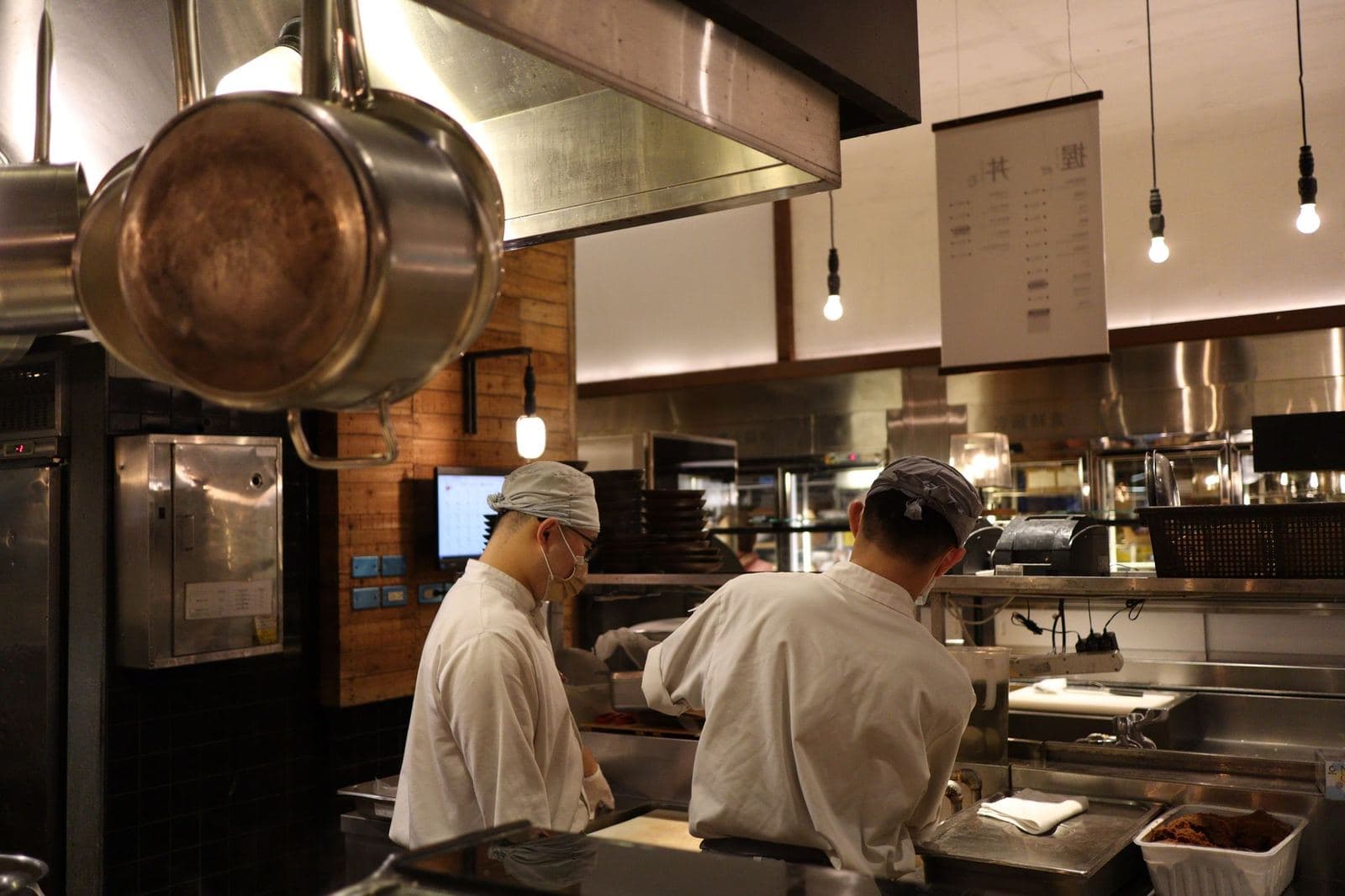 Chefs working at the pass of a restaurant kitchen
